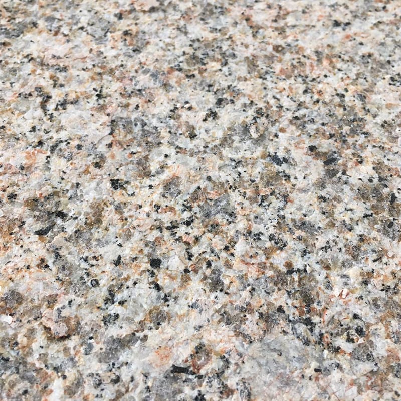 Close-up of a granite surface featuring black and white spots with a grey chipping color