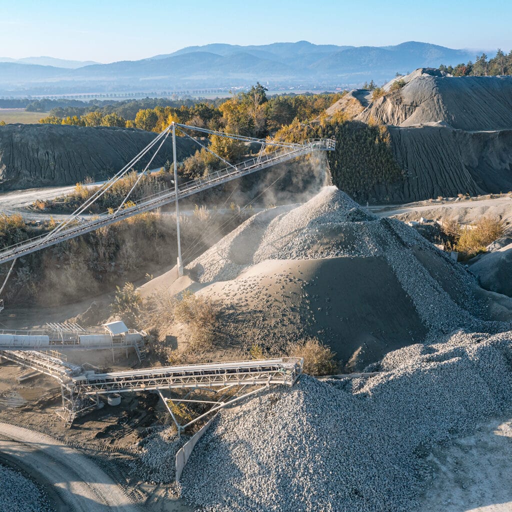 Aerial view of a granite quarry featuring a conveyor belt transporting materials across the landscape