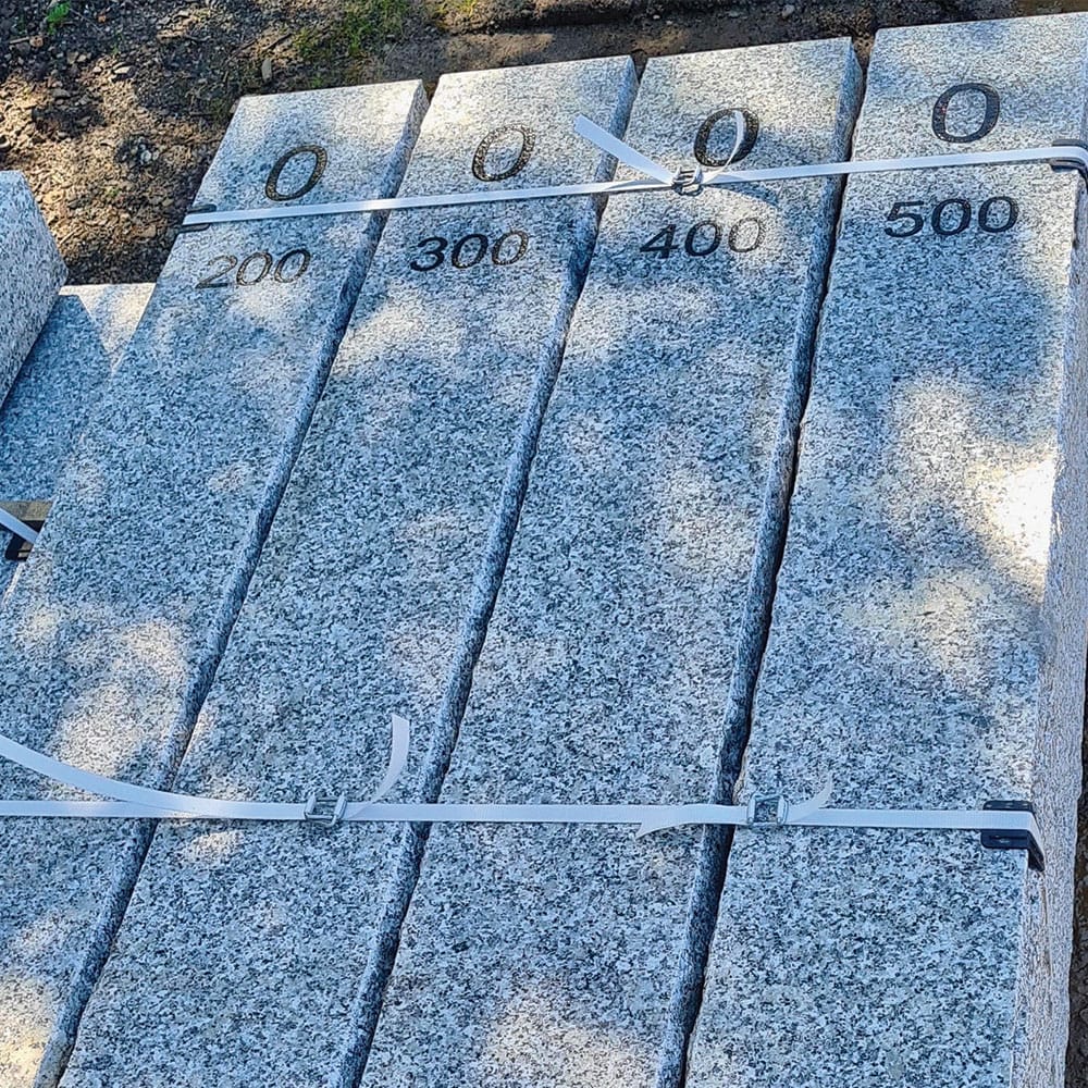 A collection of numbered granite blocks, serving as markers along a picturesque pathway