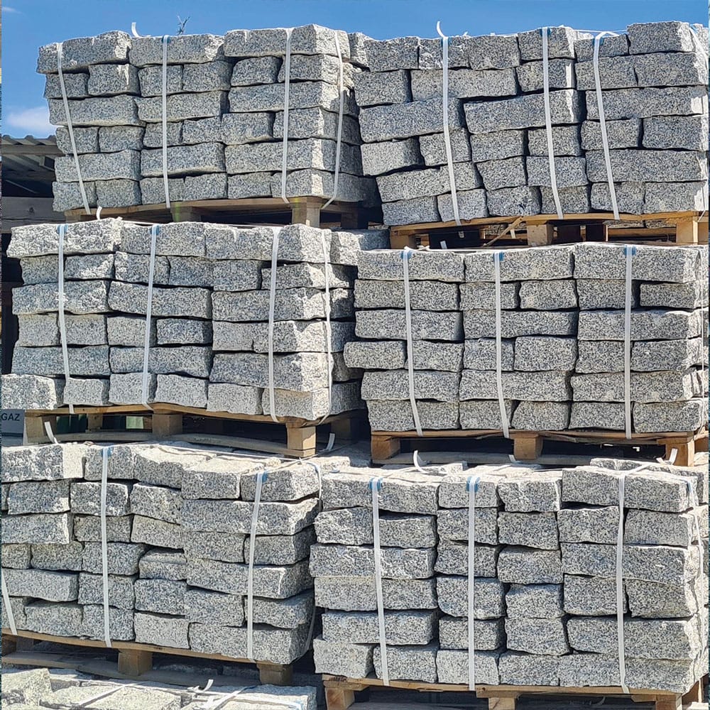 A stack of gray granite blocks on pallets, prepared for transport as wallstone materials