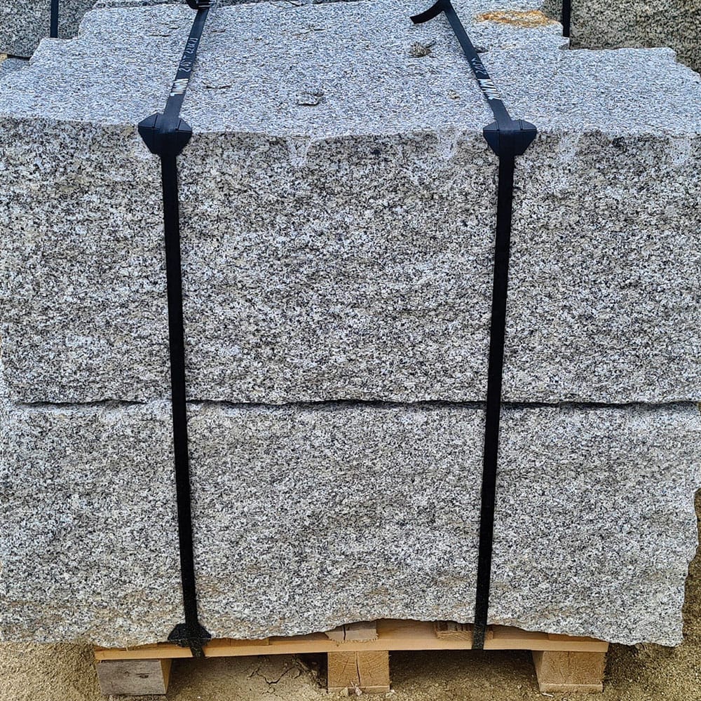 Large granite blocks on pallets, ready for transport as wallstone for construction projects.